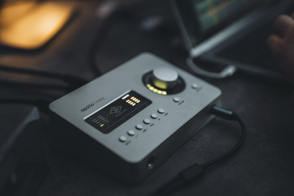 Universal Audio Apollo Solo Interface auf dem Studiotisch, im Hintergrund läuft eine Online Mixing Session am Laptop