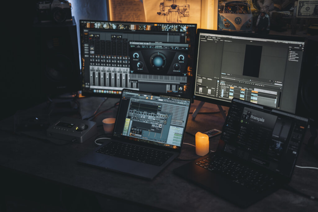 Detailansicht des RNMS Studio-Setups mit mehreren Bildschirmen, FL Studio und Universal Audio Interface in Bielefeld.